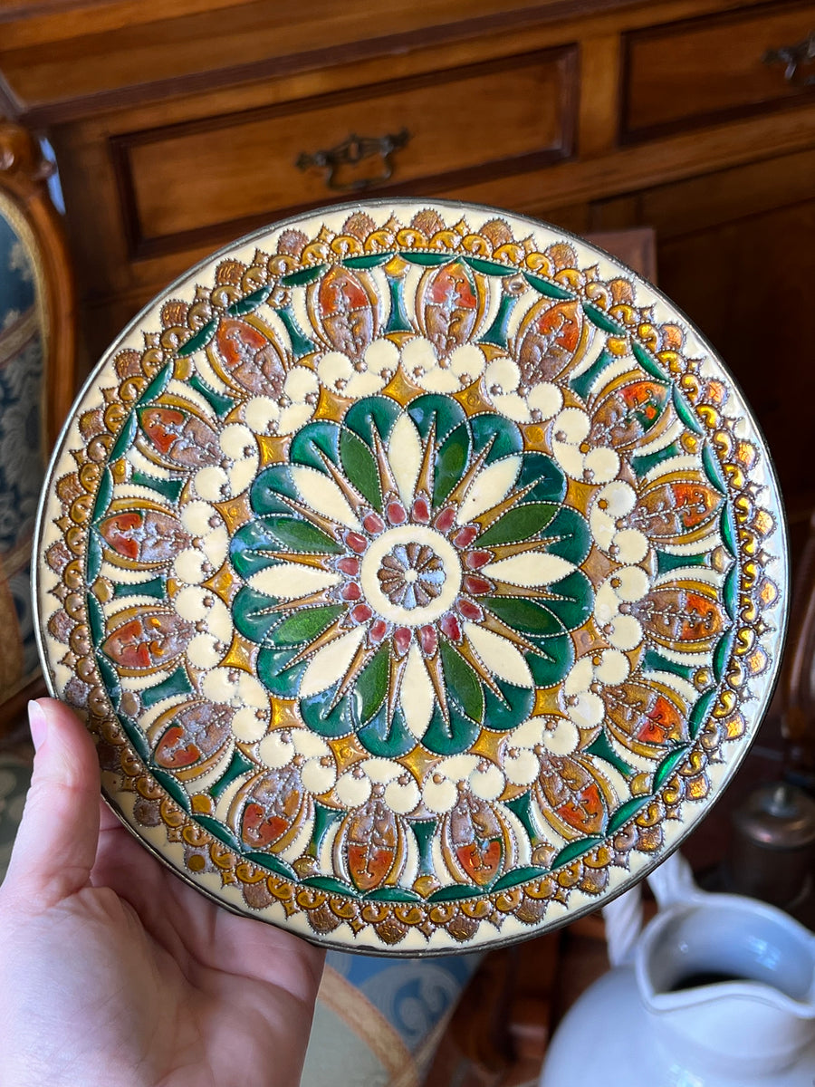 Piatto da parete in ottone smaltato con decoro floreale geometrico nei toni del verde, giallo e rosso