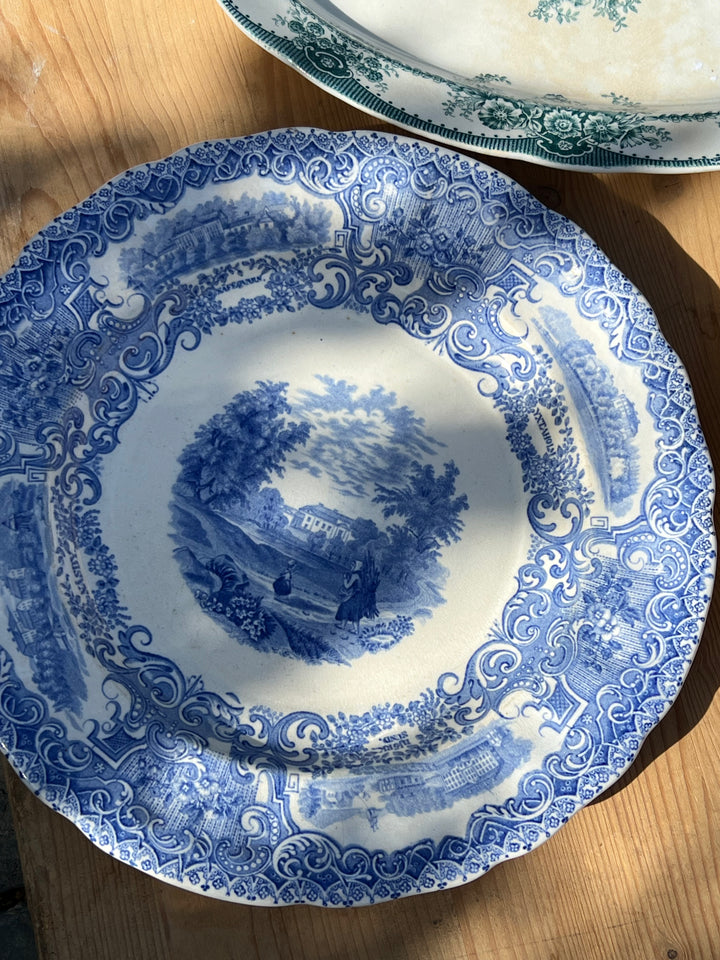 Vecchio Piatto in ceramica svedese Rorstrand con ricco decoro floreale a transfer. Nella parte centrale è presente un paesaggio con in primo piano due contadine.

Perfetto per arredare una parete o da utilizzare come piatto da portata.

Diametro 23,5 cm