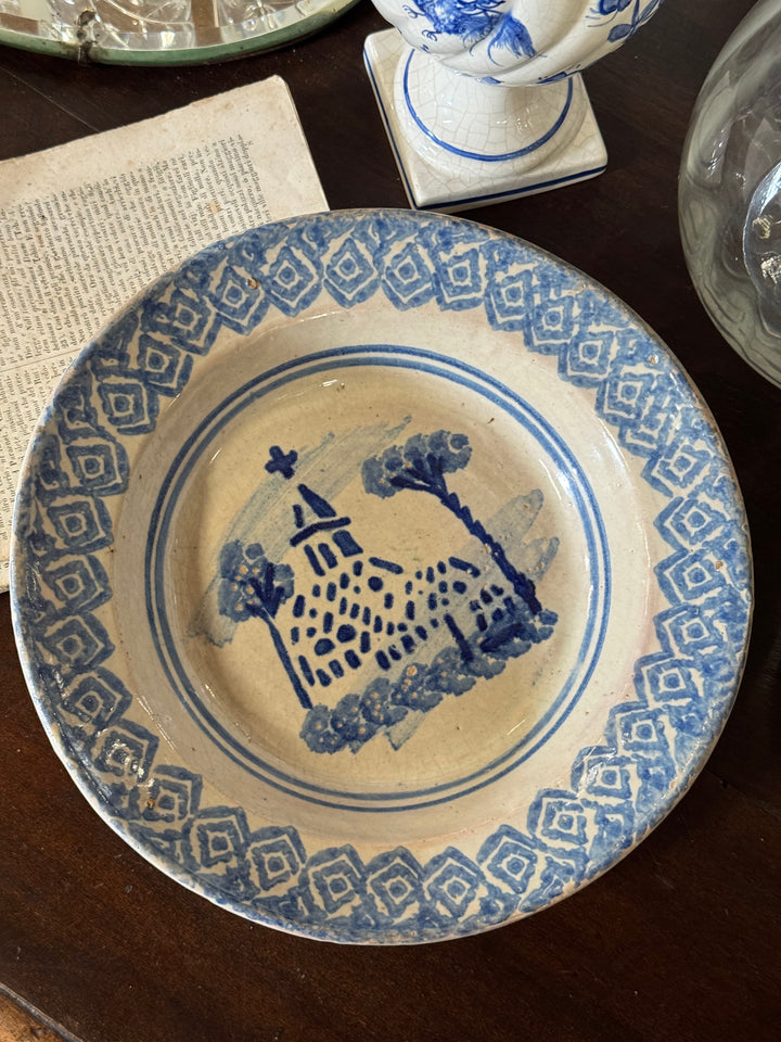 Piatto in maiolica decorata blu e bianco con scena architettonica