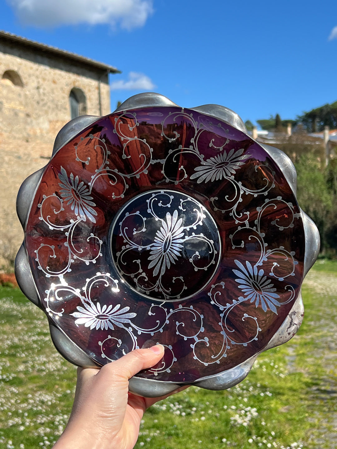 <span data-mce-fragment="1">Splendido piatto in vetro viola di Murano con decorazioni floreale in argento realizzato negli anni '60.</span><br data-mce-fragment="1"><br data-mce-fragment="1"><span data-mce-fragment="1">Misure 30x5 cm</span>