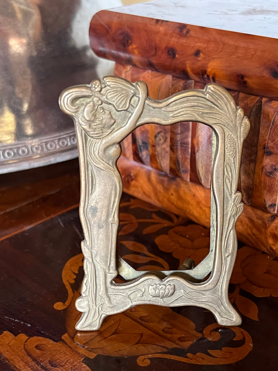 Deliziosa Cornice portafoto in stile Art Nouveau, perfetta per impreziosire piccoli ritratti o fotografie.

In ottone con finitura naturale, dalle linee fluide e motivi tipici di questo stile, con una figura femminile elegante sul lato.

Misure 10,5x7 cm