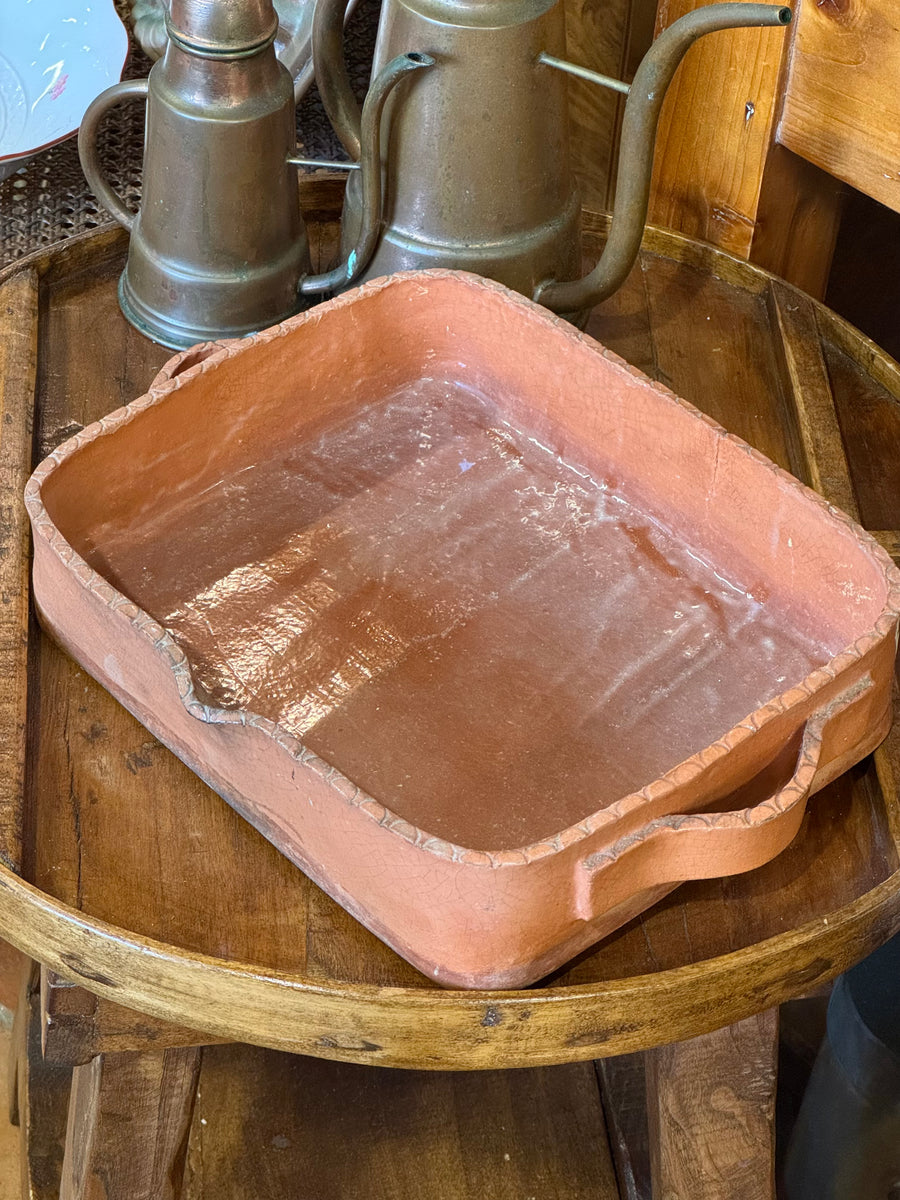 Pirofila rettangolare in terracotta smaltata color rosso mattone con manici laterali e finitura artigianale.