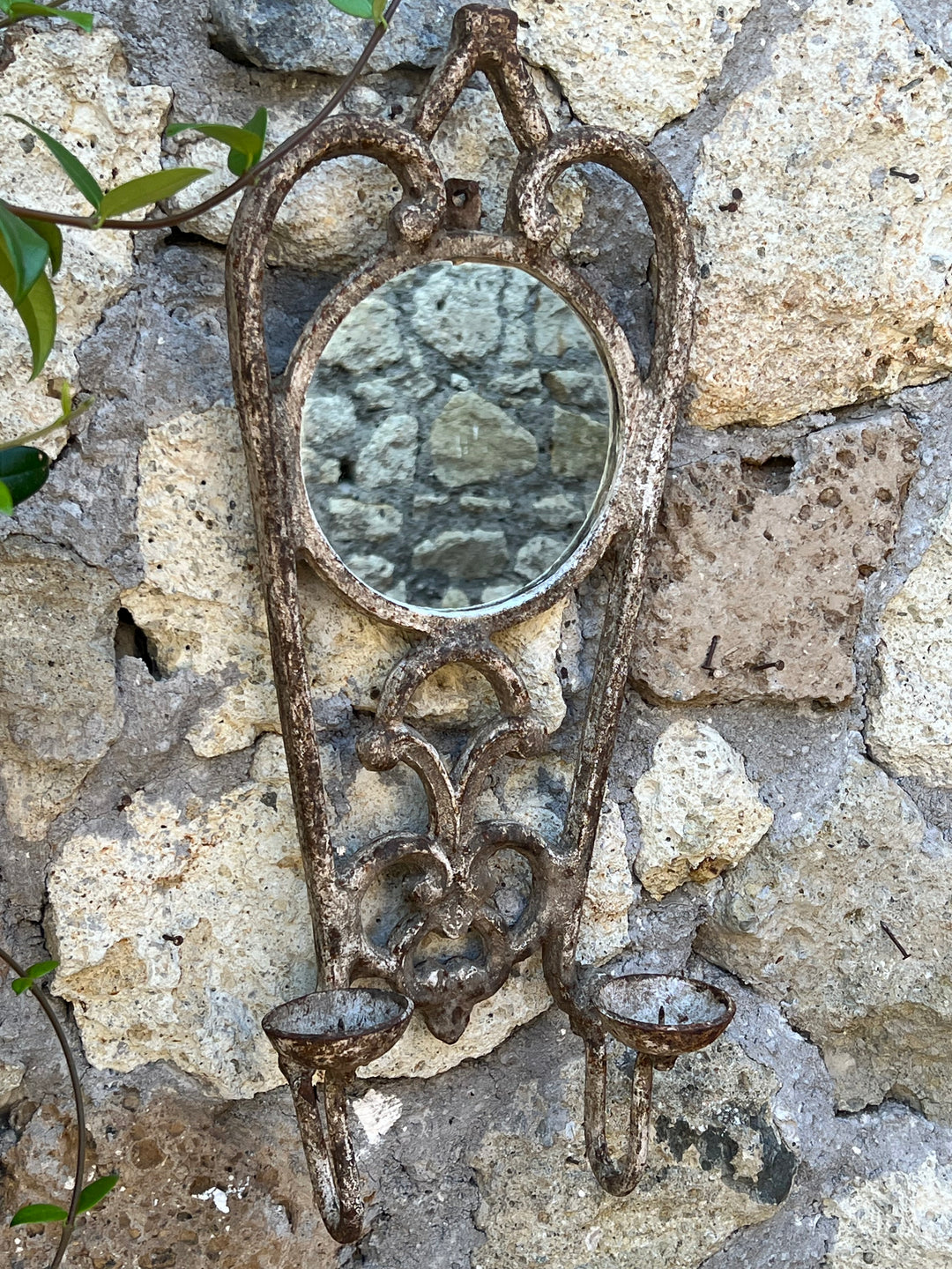 Portacandele a due luci in ferro battuto effetto anticato arricchito da un piccolo specchio circolare incastonato.

Grazie al suo fascino rustico dona a qualsiasi ambiente un tocco di charme antico.&nbsp;

Misure 22x12x55 cm&nbsp;
