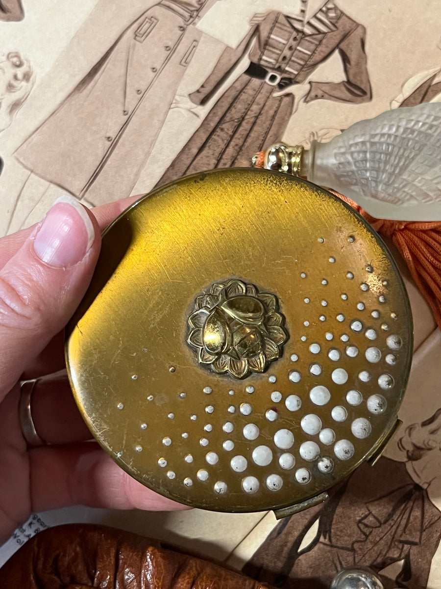 <p>Portacipria in metallo dorato della Yardley realizzato negli anni '50.</p> <p>Presenta sul coperchio un ape dorata e dei polline bianco. All'interno è presente della cipria e un piumino con il nome del marchio.</p> <p>Misure 8 cm</p>