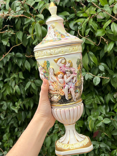 Potiche Vaso in porcellana firmata Capodimonte con decoro dipinto a mano raffigurante scena classica.   Sul coperchio è presente una sbeccatura. 