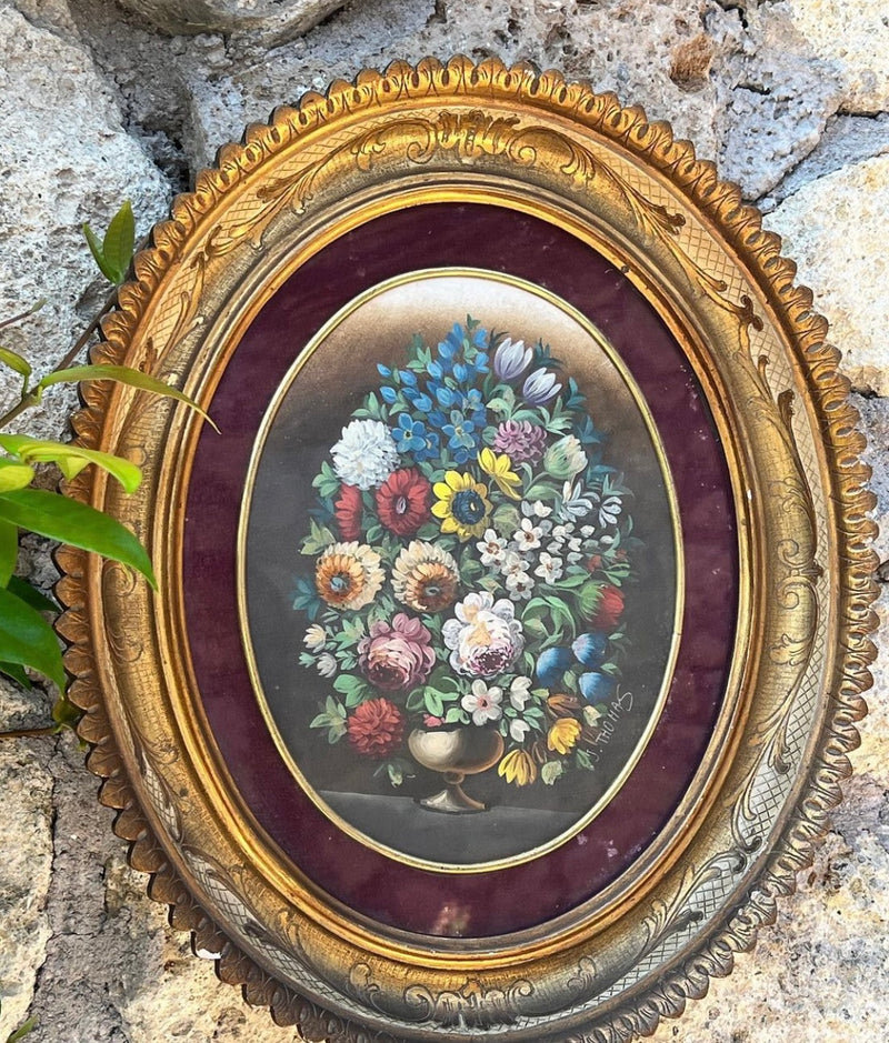 Quadro ovale raffigurante un Bouquet a tempera su carta firmato J. Thomas con cornice in legno lavorato e dorato con motivo fogliaceo.  Presenta dei difetti sulla cornice.
