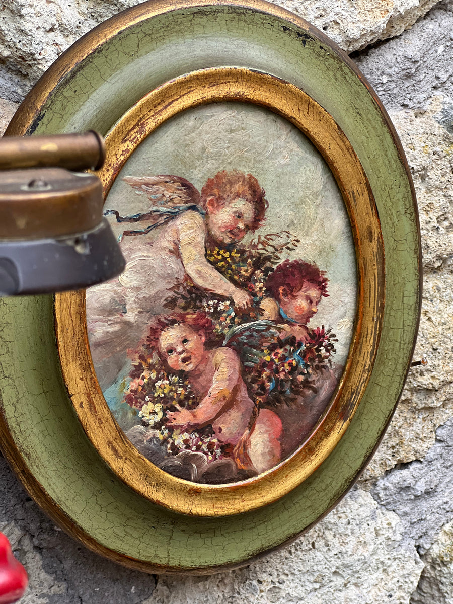 Quadro vintage con putti dipinti a olio su tela in cornice ovale verde e dorata