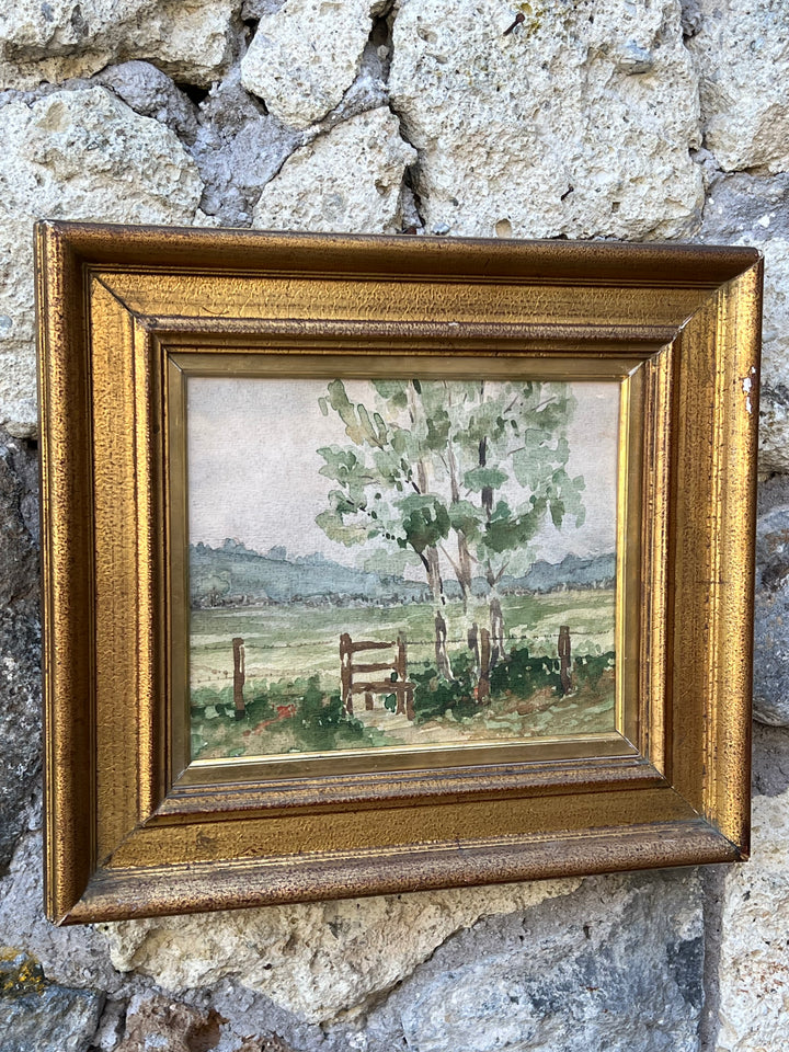 Delicato acquerello raffigurante un paesaggio campestre, dove un grande albero frondoso si erge accanto a una semplice recinzione in legno. Le colline in lontananza e la morbida stesura dei colori evocano un’atmosfera serena e contemplativa. La tecnica ad acquerello esalta la leggerezza e la freschezza della scena, tipica di un dipinto en plein air.

Il dipinto è incorniciato in una raffinata cornice, dalle linee semplici che dona ulteriore fascino e valorizza l’opera.

Misure 32,5x36,5 cm
