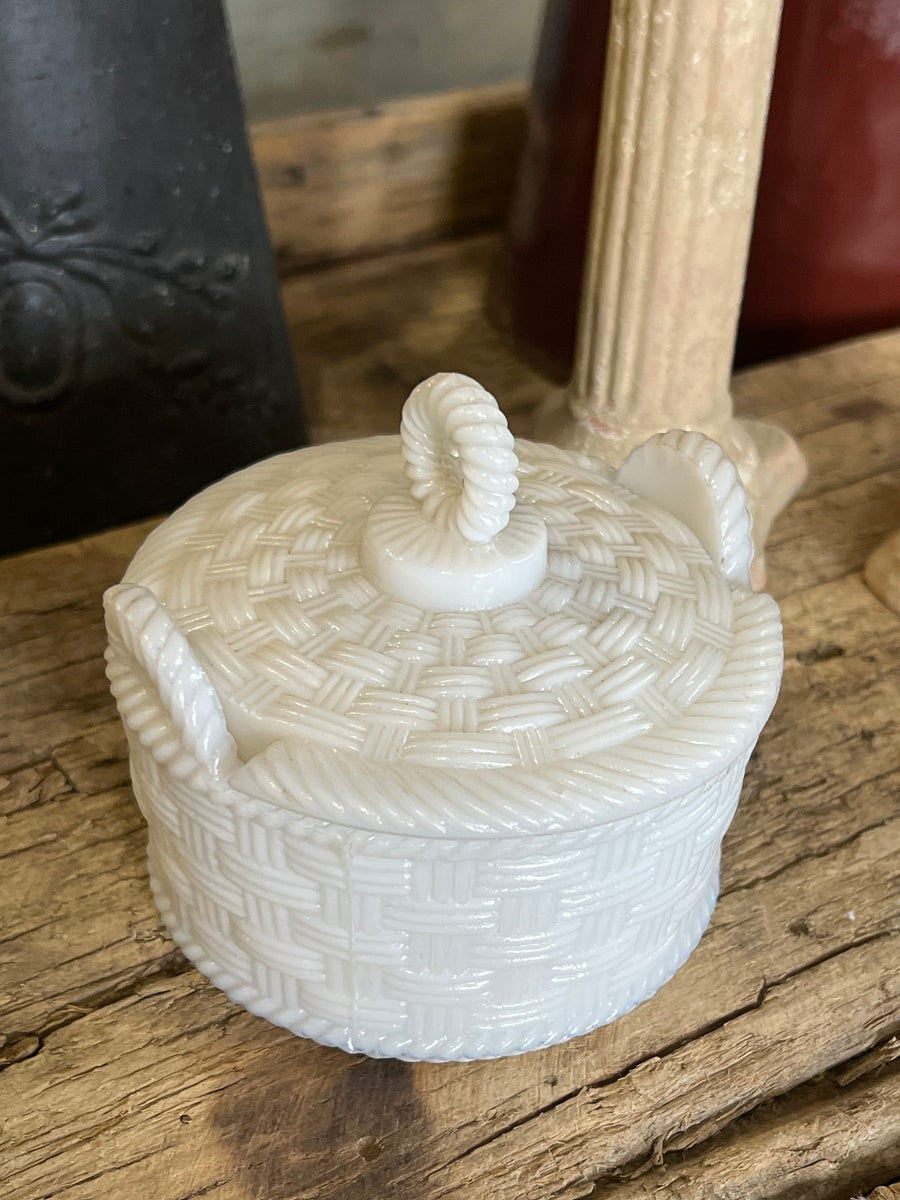 Scatolina in vetro lattimo con decorazione a intreccio che richiama un motivo a cestino completo di coperchio con manico a forma di corda intrecciata.

Perfetta per conservare piccoli oggetti o gioielli, questa scatola aggiunge un tocco di stile e luminosità a qualsiasi ambiente grazie al suo candido vetro lattimo, che dona un aspetto delicato.

Misure 10,5x10x9cm