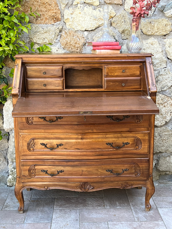 Secretaire francese a tre cassetti con anta a ribaltina ed intagli in stile rocaille. All'interno della ribalta, utilizzabile come scrittoio, sono presenti un vano e quattro cassetti, due per lato così da riporre gli oggetti di piccola dimensione. Perfetto per un ingresso, una piccola nicchia o una camera da letto, un mix tra funzionalità e bellezza in un meraviglioso color noce.  Misure 100x43x90h cm&nbsp;