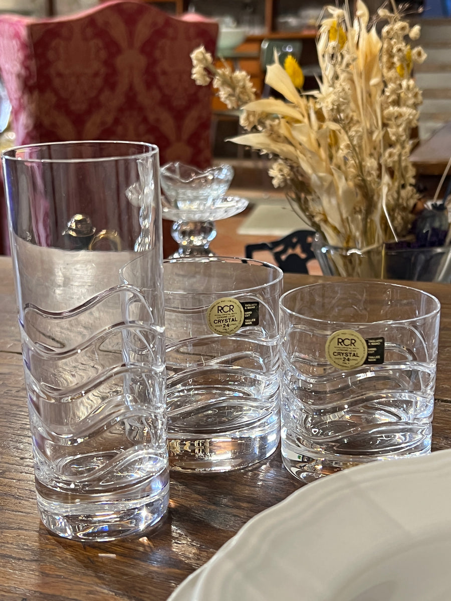 Originale Set di diciotto, sei per tipo, bicchieri prodotti dalla Royal Crystal Rock negli anni ’70 in Italia. Struttura in cristallo di forma cilindrica con onde su tutto il corpo a decorazione. Forme perfette per acqua e bevande. Sono presenti sopra parte dei bicchieri gli adesivi di originalità.