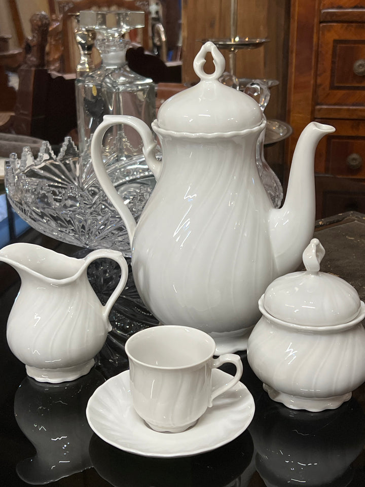 Splendido Servizio da caffè da dodici persone firmato Seltmann Weiden, modello "Regina", noto per la sua eleganza senza tempo e la qualità della porcellana tedesca. Il design delicato e le linee sinuose rendono questo set un pezzo raffinato, ideale per donare un tocco di classe alla vostra tavola. Ogni elemento del servizio è impreziosito da una lucentezza unica e da un decoro ad onda.

Misure Caffettiera 20x25x15 cm, lattiera 10x8x10,5 cm, tazzina 6x6 cm e piattino 12 cm, zuccheriera 9x12 cm