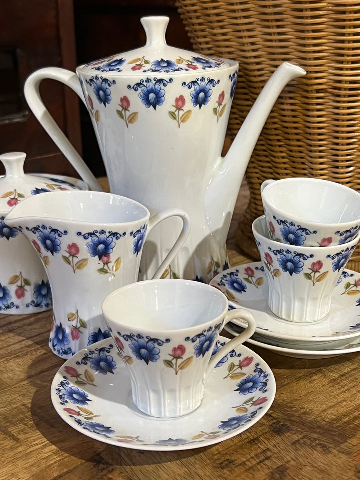Servizio da caffè da dodici persone della Porzellain Fabrik Bavaria Germany.  Decorato con motivi floreali di colore blu e rosa e composto da tazzina, piattino, caffettiera, zuccheriera e lattiera.  tazzine 6,5x5,5 cm piattino 12 cm lattiera 7,5x11x9 cm  zuccheriera 10,5x11 cm caffettiera 20x12x20cm