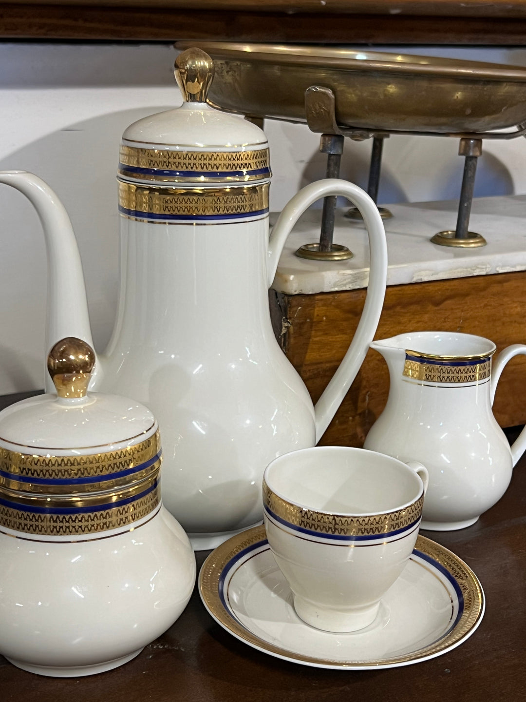 Elegante Servizio da caffè per dodici persone della rinomata manifattura tedesca Seltmann, Questo set è caratterizzato da un raffinato decoro con dettagli dorati e un bordo blu intenso, che conferisce un tocco di lusso e raffinatezza ad ogni momento di convivialità. La finitura lucida e i dettagli dorati sono perfettamente realizzati, rispecchiando la qualità artigianale di Seltmann.

Misure Caffettiera 19x13x22 cm; lattiera 9x8x10 cm; zuccheriera 9x11 cm; tazzina 6,5x6 cm e piattino 12 cm