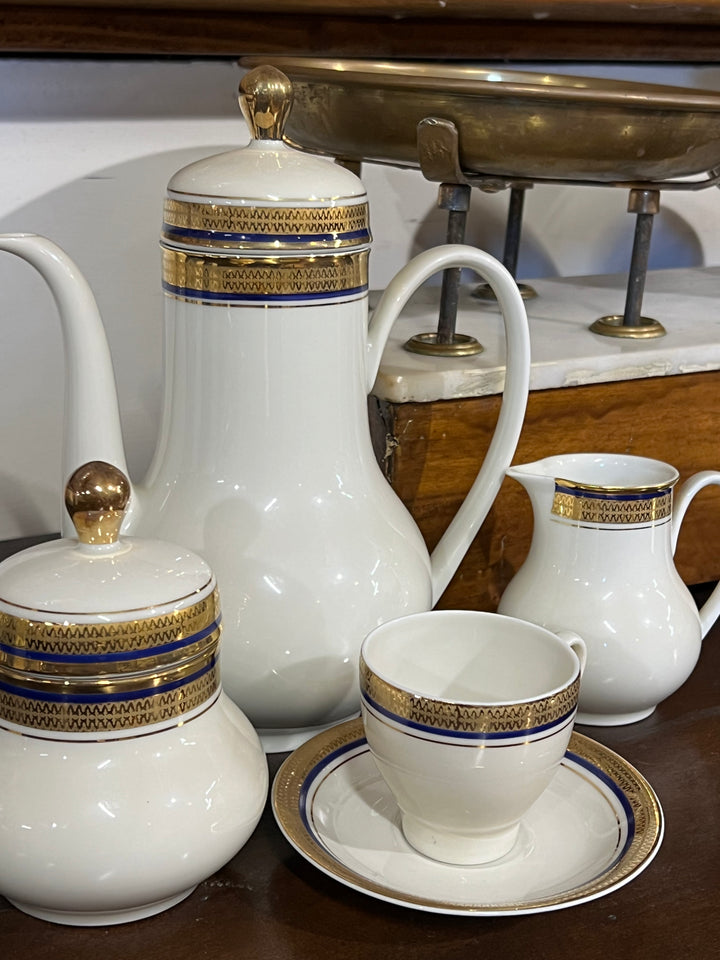 Elegante Servizio da caffè per dodici persone della rinomata manifattura tedesca Seltmann, Questo set è caratterizzato da un raffinato decoro con dettagli dorati e un bordo blu intenso, che conferisce un tocco di lusso e raffinatezza ad ogni momento di convivialità. La finitura lucida e i dettagli dorati sono perfettamente realizzati, rispecchiando la qualità artigianale di Seltmann.

Misure Caffettiera 19x13x22 cm; lattiera 9x8x10 cm; zuccheriera 9x11 cm; tazzina 6,5x6 cm e piattino 12 cm