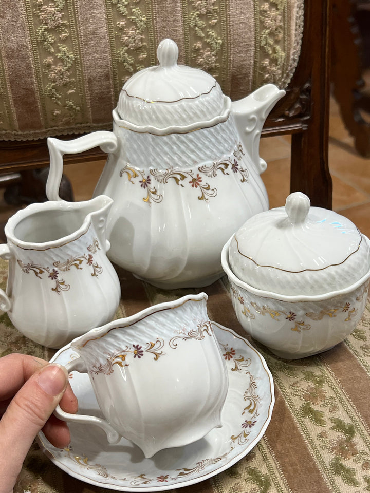 Elegante servizio da tè in porcellana finissima firmata Schirnding Bavaria, decorato con raffinati motivi floreali e dettagli dorati. Un set perfetto per momenti di convivialità o per arricchire la vostra collezione di porcellane.

Composto da dodici tazze e dodici piattini e completo di teiera, zuccheriera e lattiera.

Misure Teiera 20x13x19 cm; zuccheriera 10x12 cm; lattiera 10x8x10 cm; tazza tè 8x7 cm piattino 14 cm&nbsp;