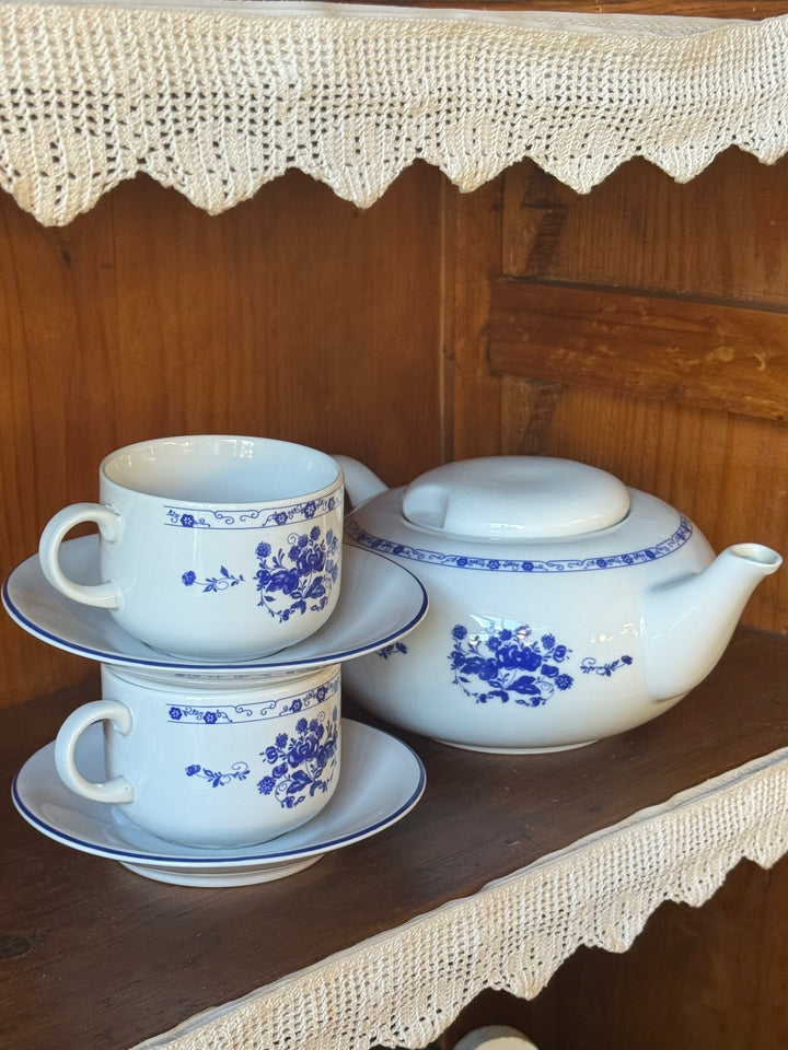 Servizio da tè vintage Cipa Italia in ceramica bianca con decorazioni floreali blu, teiera con coperchio e tazza con piattino coordinato.