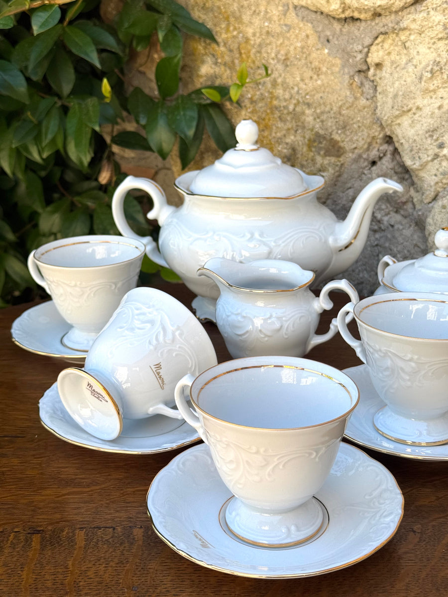 Servizio da tè vintage Masoni Italia in porcellana bianca con decori floreali in rilievo e bordi dorati, composto da teiera, zuccheriera, lattiera e tazza con piattino.