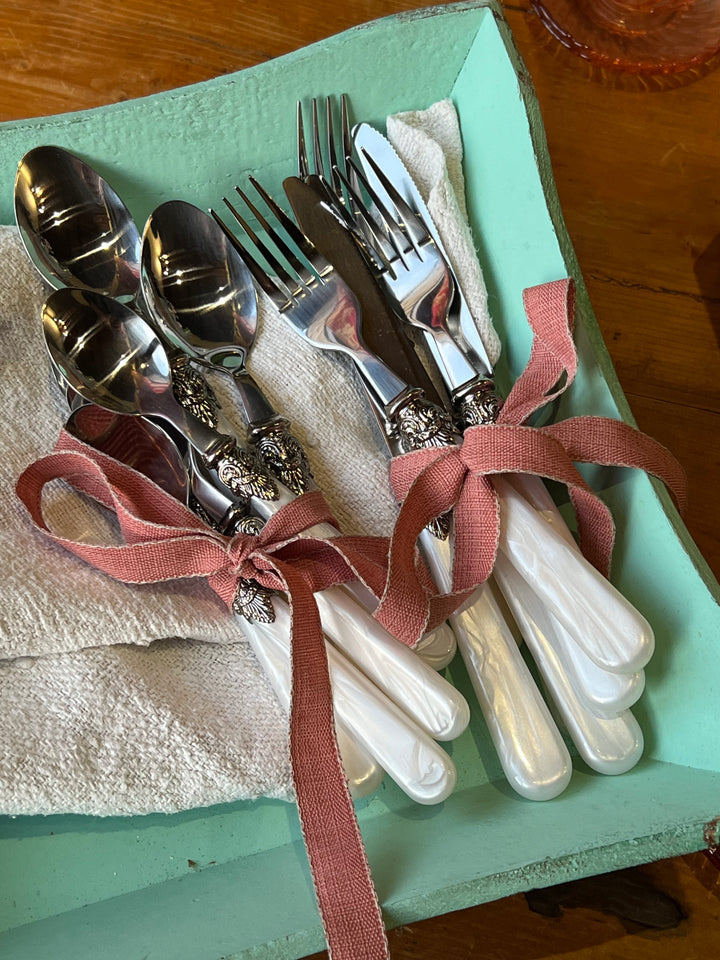Raffinato Servizio di posate da dodici persone con manico in finta madreperla con dettagli in acciaio. Il set è composto da forchetta, coltello, cucchiaio e cucchiaino.

Perfetto per aggiungere alla tua tavola un tocco di eleganza e per celebrare momenti speciali con stile.&nbsp;
