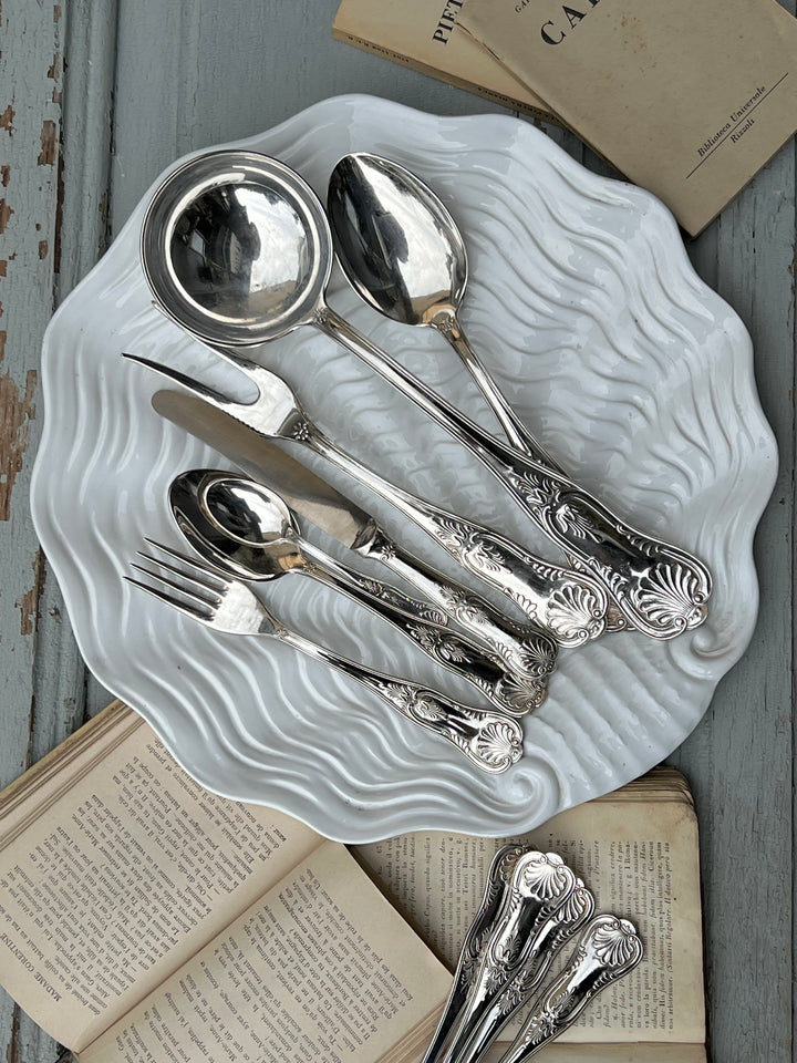 Raffinato Servizio di posate da sei persone realizzato in silverplate, completo di coltelli, forchette, cucchiai, cucchiaini e tre posate da servizio. Ogni pezzo è finemente decorato sul manico con motivi a conchiglia, dal design classico e senza tempo. Il set è custodito in una scatola originale con rivestimento interno in tessuto. Sono perfette per una cena speciale o per aggiungere un tocco di classe alla quotidianità.

Composizione del set: 6 Coltelli 25 cm; 6 Forchette 20cm; 6 Cucchiai 20 cm;6 Cucchiai