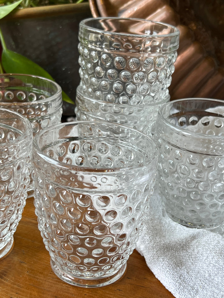Set di bicchieri&nbsp; in vetro trasparente caratterizzati da un raffinato motivo a rilievo a bolle, che conferisce un tocco di originalità e stile.&nbsp;

Perfetti per ogni occasione, dal servizio quotidiano alle cene formali, questi bicchieri aggiungono un tocco di classe alla vostra tavola.

Misure 9x10 cm