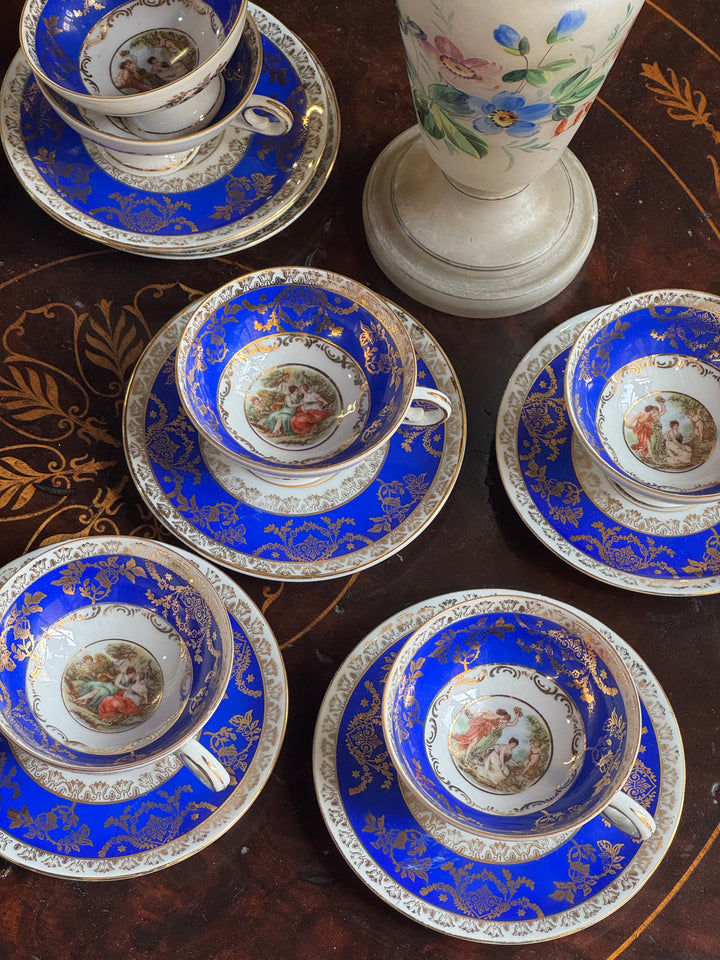 Set di tazzine da caffè in porcellana blu cobalto con decorazioni dorate e scena galante centrale, produzione Bavaria Germania