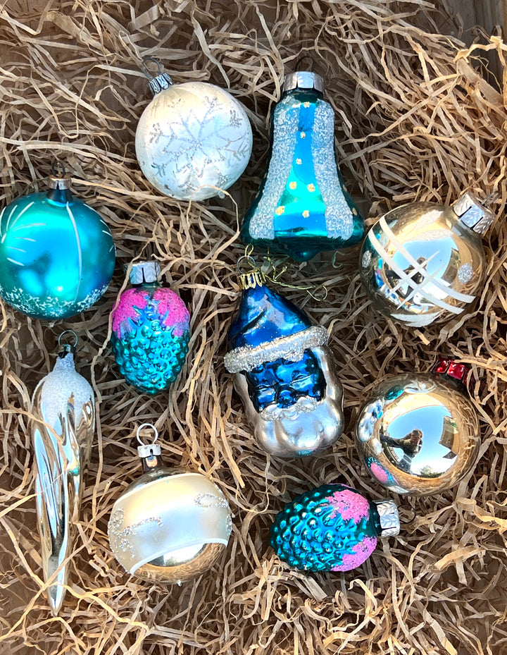 Set di dieci palline in vetro vintage dai toni dell'argento e del blu. Pezzi unici, piani di storia ed incanto, pronti a brillare sul tuo albero.