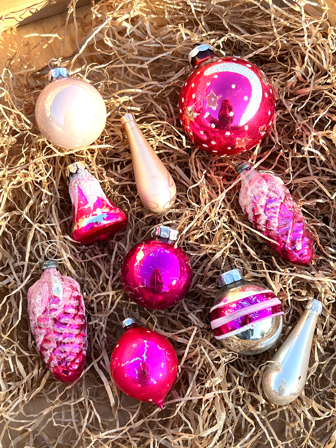 Set di dieci palline in vetro vintage dai toni dell'argento e del rosa. Pezzi unici, piani di storia ed incanto, pronti a brillare sul tuo albero.