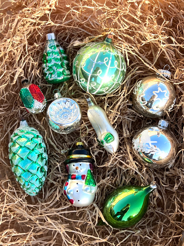 Set di dieci palline in vetro vintage dai toni dell'argento e del verde. Pezzi unici, piani di storia ed incanto, pronti a brillare sul tuo albero.