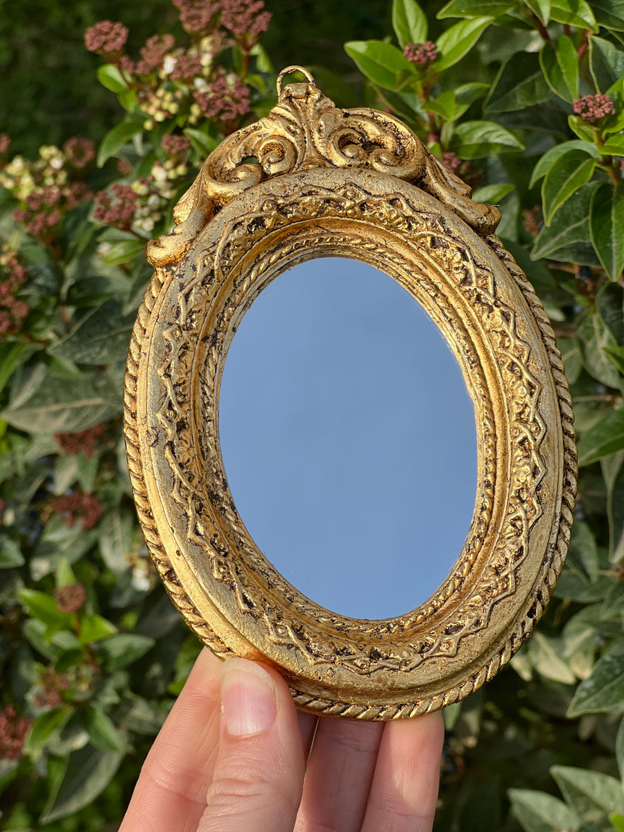 Specchietto di misure 14x10cm, di ispirazione barocca con cornice intagliata e dorata a foglia oro. Su tutta la cornice è presente un elaborato motivo a rilievo.

Con una maestria che trascende il tempo, i nostri specchietti sono capolavori realizzati a mano che catturano l'essenza dell'eleganza barocca. Ogni cornice, finemente scolpita e rifinita con foglia d'oro, è frutto di tecniche di antichizzazione che regalano un'anima vissuta e senza tempo ad ogni pezzo.
