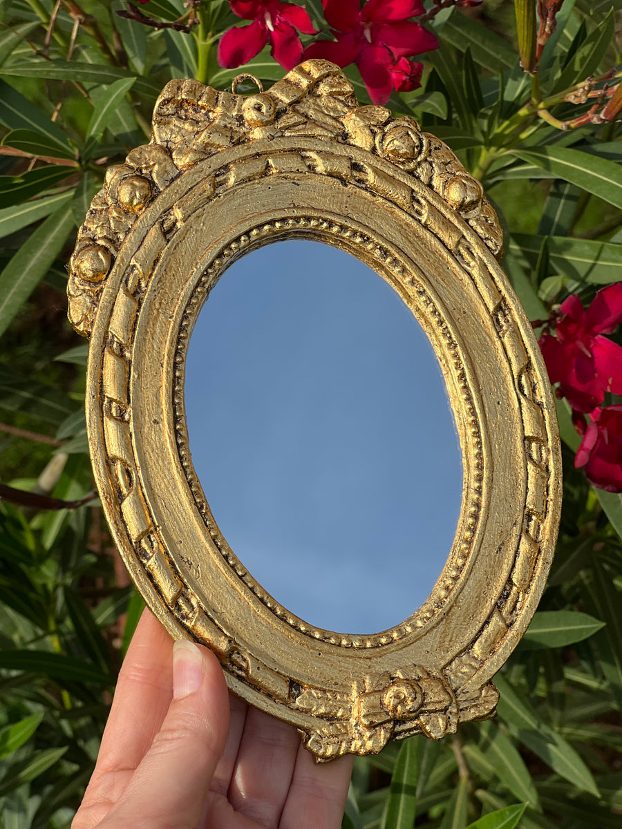 Specchietto di misure 13x19 cm, di ispirazione barocca con cornice intagliata e dorata a foglia oro. Nella parte superiore è presente un dettaglio a fregio e lungo la cornice un dettaglio ad intreccio.

Con una maestria che trascende il tempo, i nostri specchietti sono capolavori realizzati a mano che catturano l'essenza dell'eleganza barocca. Ogni cornice, finemente scolpita e rifinita con foglia d'oro, è frutto di tecniche di antichizzazione che regalano un'anima vissuta e senza tempo ad ogni pezzo.