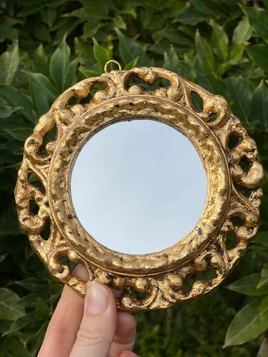Specchietto di misure 13,5 cm, di ispirazione barocca con cornice intagliata e dorata a foglia oro. Su tutta la cornice è presente un elegante motivo intagliato.

Con una maestria che trascende il tempo, i nostri specchietti sono capolavori realizzati a mano che catturano l'essenza dell'eleganza barocca. Ogni cornice, finemente scolpita e rifinita con foglia d'oro, è frutto di tecniche di antichizzazione che regalano un'anima vissuta e senza tempo ad ogni pezzo.
