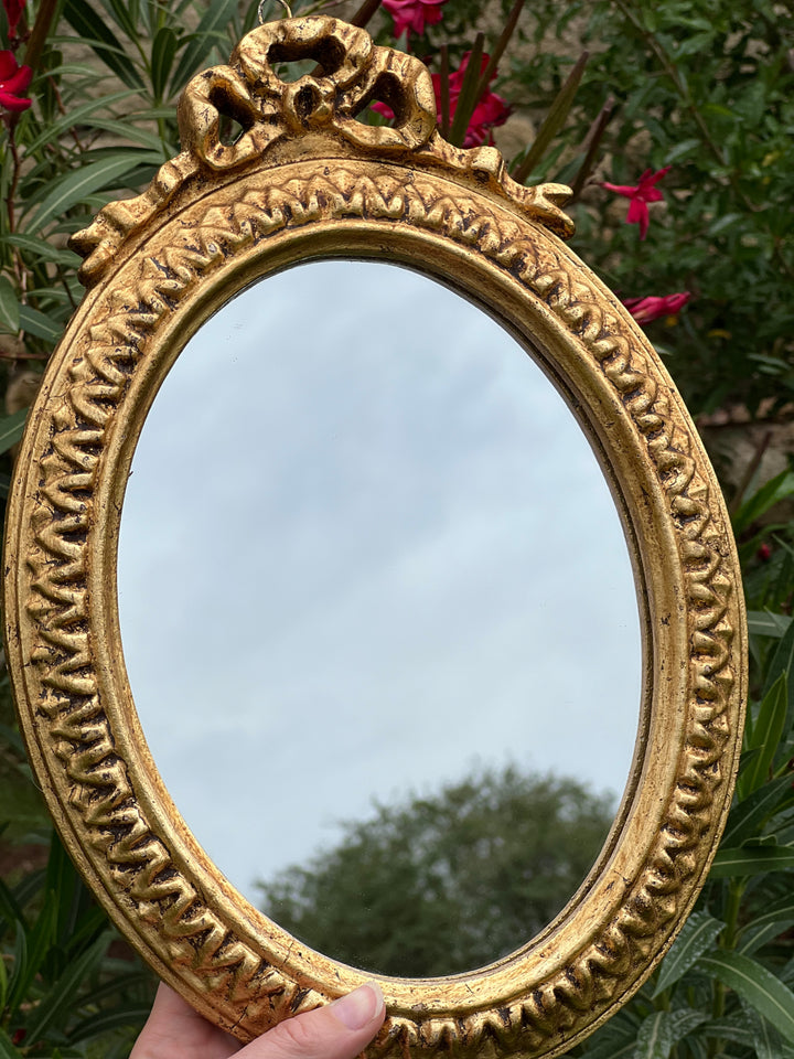 Specchietto di misure 23x33 cm, di ispirazione barocca con cornice intagliata e dorata a foglia oro. Nella parte superiore è presente un dettaglio a fregio e lungo la cornice un motivo geometrico.

Con una maestria che trascende il tempo, i nostri specchietti sono capolavori realizzati a mano che catturano l'essenza dell'eleganza barocca. Ogni cornice, finemente scolpita e rifinita con foglia d'oro, è frutto di tecniche di antichizzazione che regalano un'anima vissuta e senza tempo ad ogni pezzo.