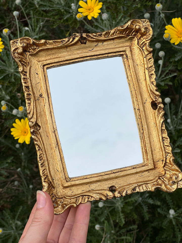 Specchietto di misure 17x19 cm, di ispirazione barocca con cornice intagliata e dorata a foglia oro. Su tutta la cornice è presente un elaborato motivo a rilievo.

Con una maestria che trascende il tempo, i nostri specchietti sono capolavori realizzati a mano che catturano l'essenza dell'eleganza barocca. Ogni cornice, finemente scolpita e rifinita con foglia d'oro, è frutto di tecniche di antichizzazione che regalano un'anima vissuta e senza tempo ad ogni pezzo.