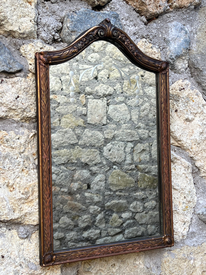 Delizioso Specchio con cornice dalla forma particolare realizzata in legno intagliato con specchio molato con decoro floreale inciso.

Ideale per chi vuole arredare un piccolo spazio, un bagno o un ingresso.

Misure 32x52 cm&nbsp;