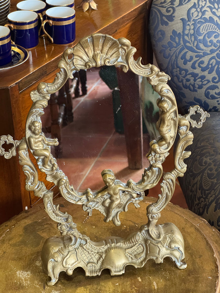 Specchio da tavolo in bronzo dorato con cornice rococò e putti decorativi