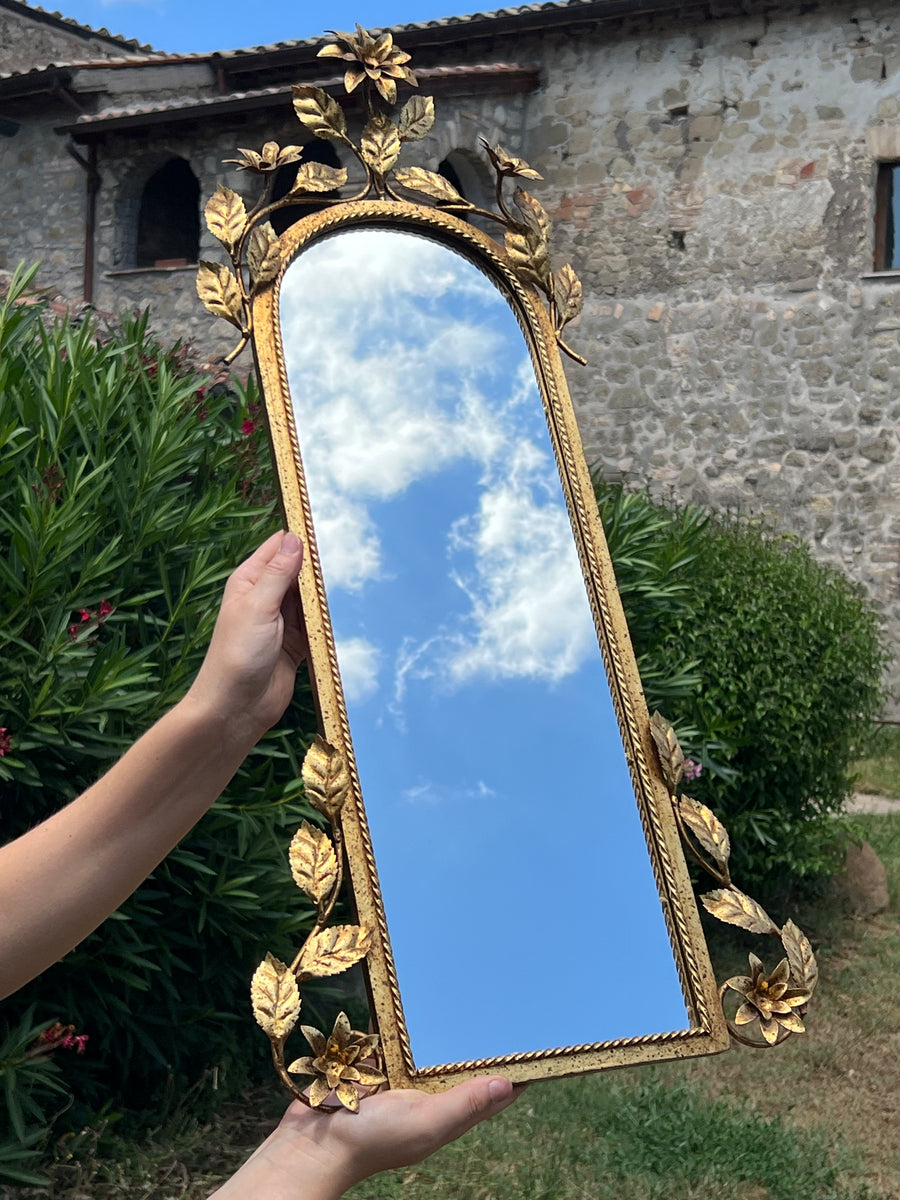 Specchio vintage in metallo dorato con cornice decorata da fiori e foglie a rilievo