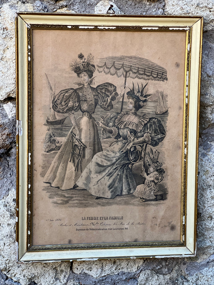 <p>Stampa moda femminile francese vintage "La femme et la famille" con cornice in legno bianca e dorata.</p> <p>La cornice presenta qualche difetto.</p> <p>Misure 30x45 cm</p>