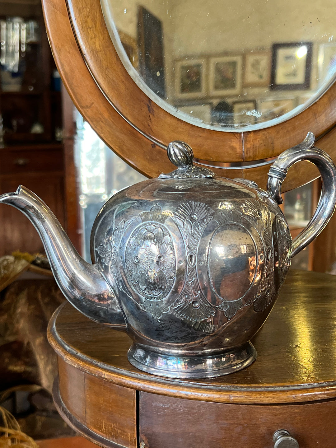 Raffinata Teiera inglese in argento placcato arricchita da elaborati motivi decorativi incisi a mano. Un pezzo dal fascino intramontabile, ideale per arricchire una collezione o donare un tocco di eleganza a qualsiasi ambiente.

Misure 25x15x16 cm