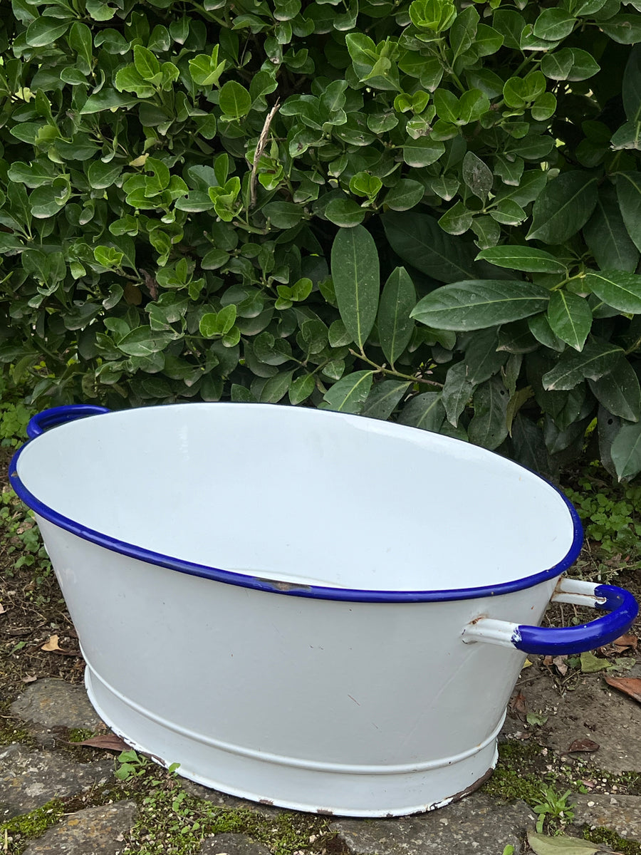 Tinozza in latta smaltata bianco con bordo blu realizzata dal marchio Due Leoni.&nbsp;

La sua forma classica e le maniglie laterali robuste la rendono ideale per molteplici utilizzi, sia pratici che decorativi. Perfetta come contenitore per fiori o piante, oppure come elemento d'arredo in una cucina o un giardino.

Perfetto per chi ama lo stile rustico e vuole arredare con carattere retrò.

Misure 69x39x22 cm