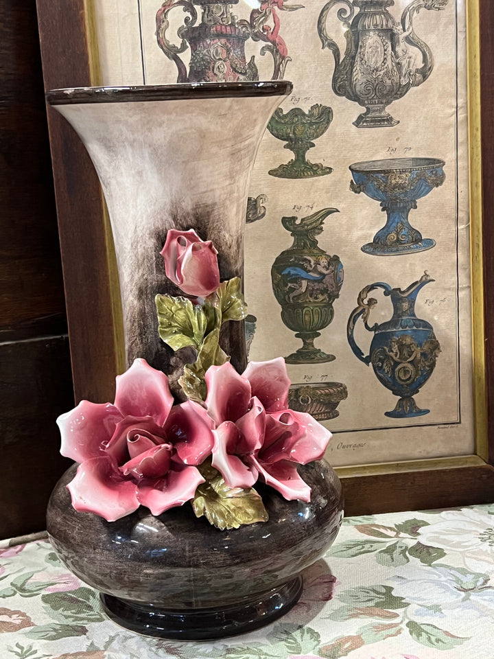 Vaso realizzato dal marchio italiano Bassano, rinomato per la sua fine ceramica, presenta un design elegante con decorazioni floreali in rilievo che aggiungono profondità e texture. Le rose rosa delicate emergono dalla base scura del vaso, creando un contrasto visivo straordinario che cattura l'attenzione.&nbsp;

Diametro 17 cm Altezza 29 cm&nbsp;
