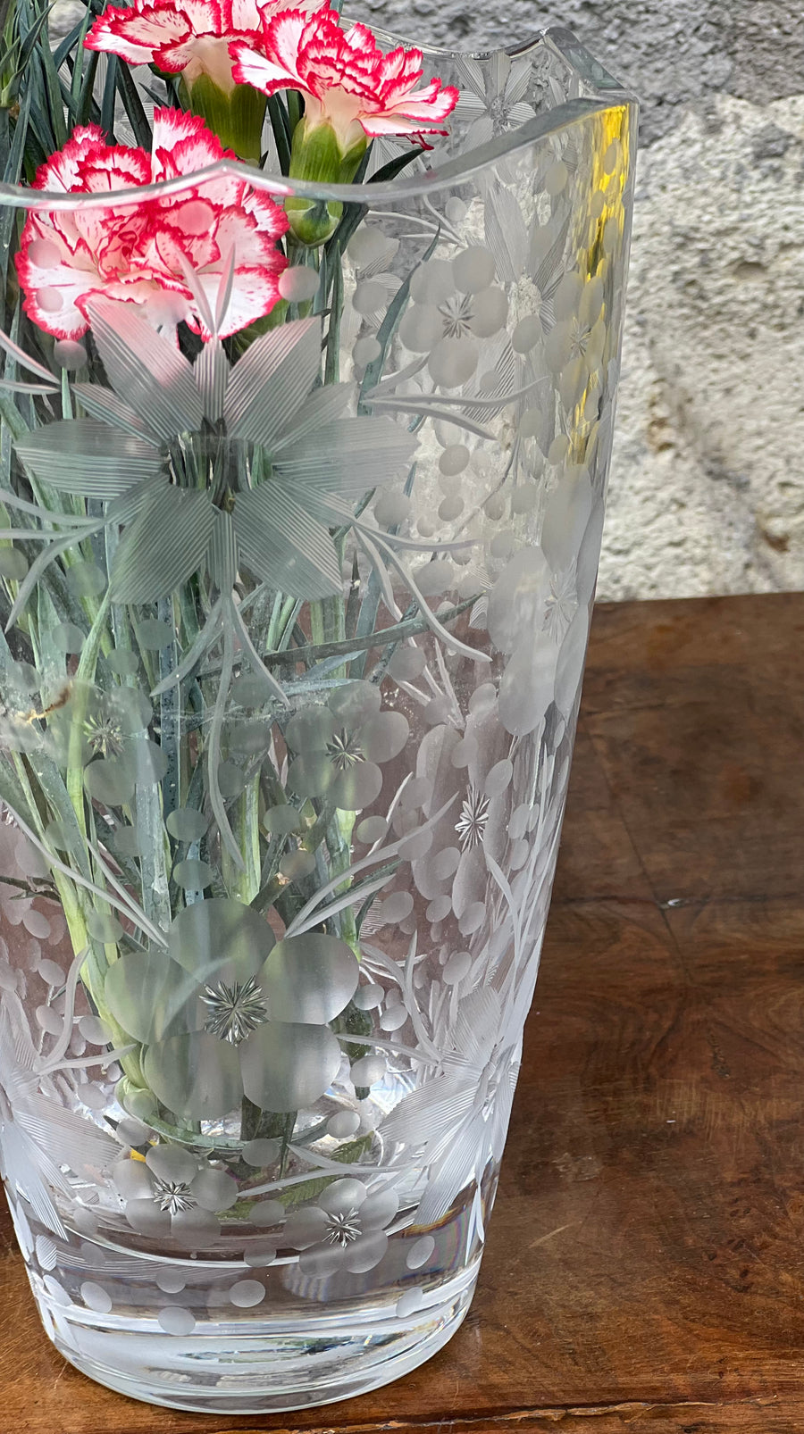 <p>Vaso in cristallo con delizioso decoro floreale inciso e con bordo ondulato.&nbsp;</p> <p>Come visibile in foto in alcuni punti del bordo ci sono delle sbeccature.</p> <p>Misure 15x25 cm</p>