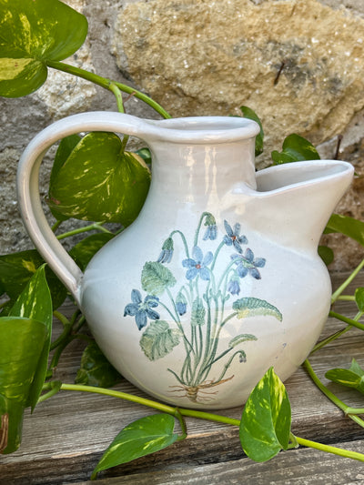 Brocca in ceramica con decorazione floreale blu presente su un fianco.