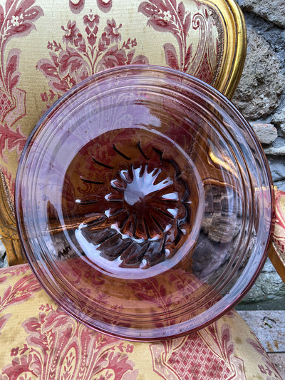 Grande centrotavola in vetro viola. Sul bordo esterno è presente una decorazione a cerchi concentrici. 