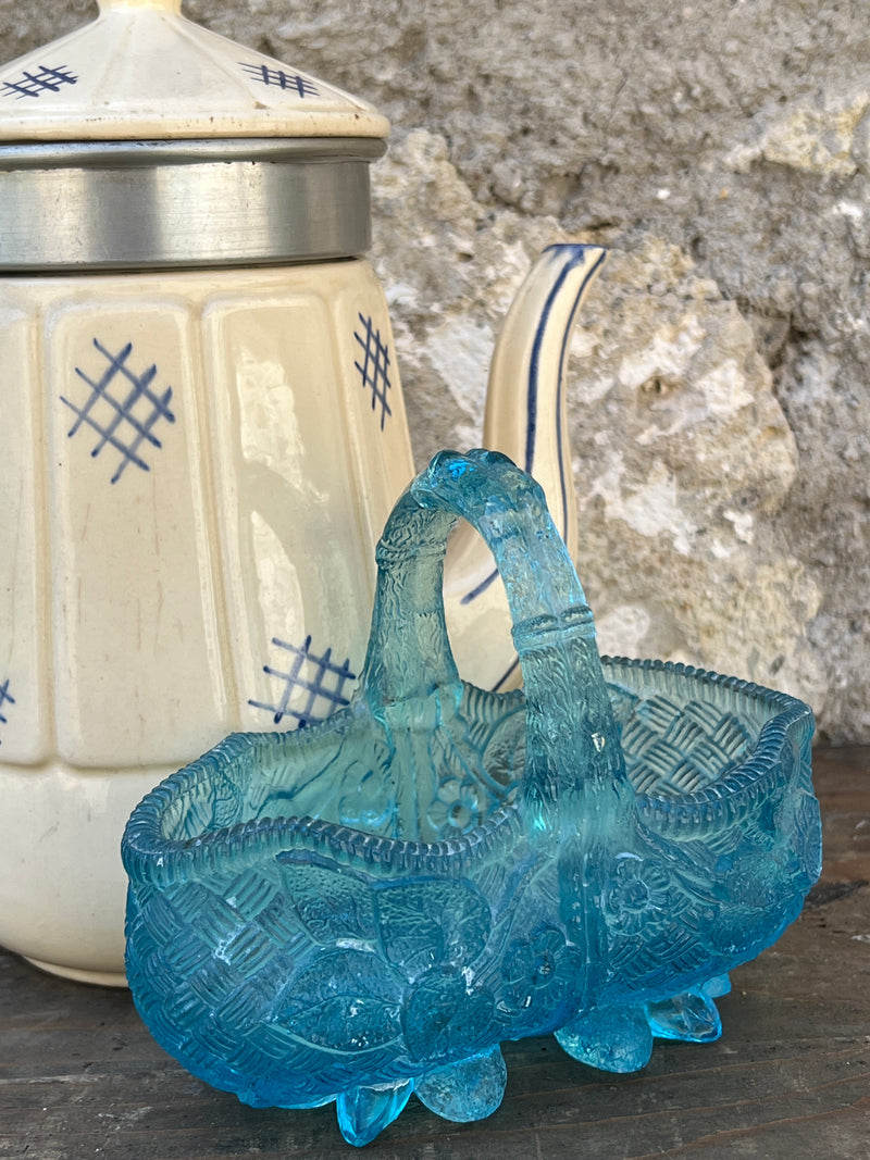 Cestino vintage in vetro azzurro con decorazione floreale e manico centrale.