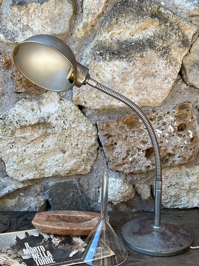 Lampada da tavolo industriale vintage, orientabile grazie al braccio snodabile. L'intera struttura è in metallo.