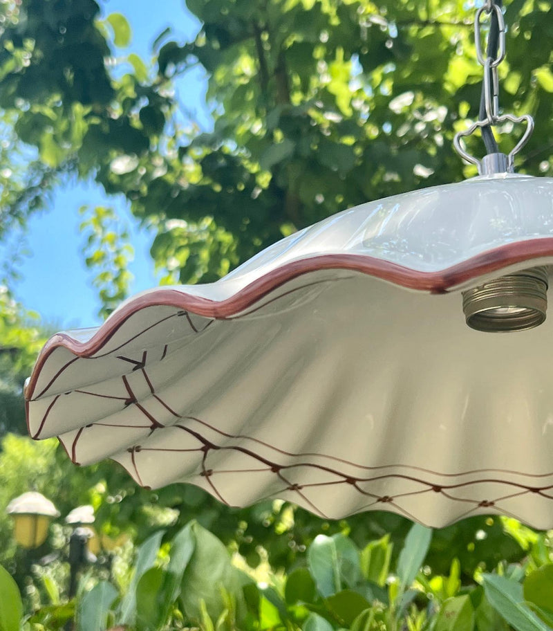 Lampadario in ceramica con bordo ondulato e decorazioni dipinte a mano di colore rosso scuro.