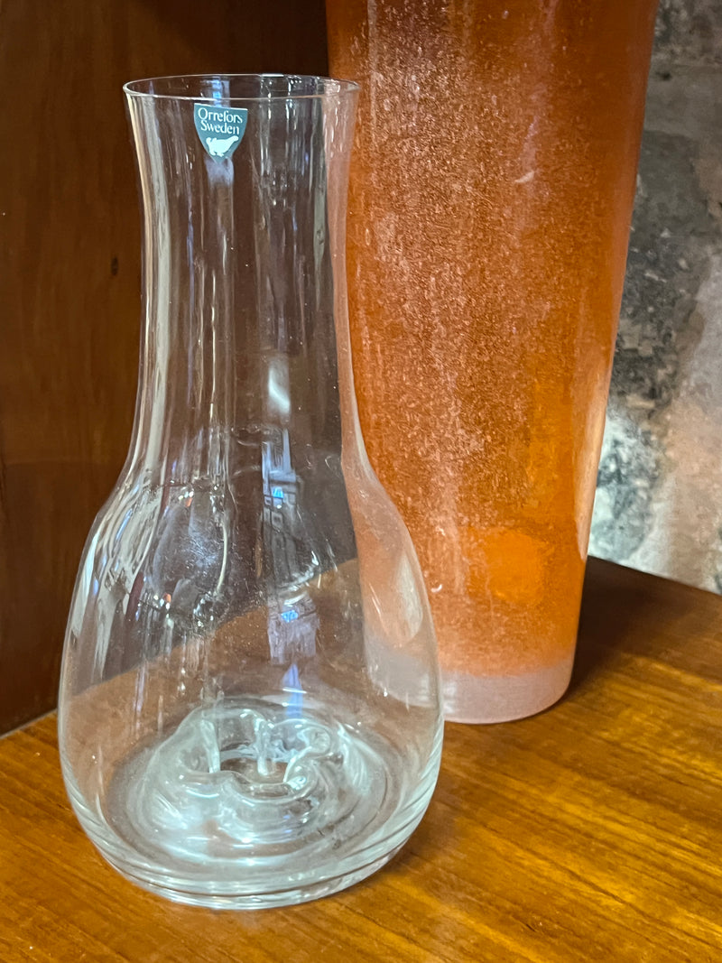 Vaso in vetro del marchio svedese Orrefors, alla base presenta una decorazione a quadrifoglio.  Misure: Diametro 11 cm, Altezza 21 cm