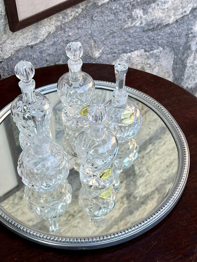Elegante vassoio specchiato vintage con cornice in metallo lavorato.  Perfetto come porta profumi o per creare un piccolo angolo bar.  Misure: Diametro 26 cm, Altezza 2 cm